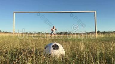 快乐的父亲和女儿在绿茵场上用足球大门打球。 快乐的家庭踢足球。